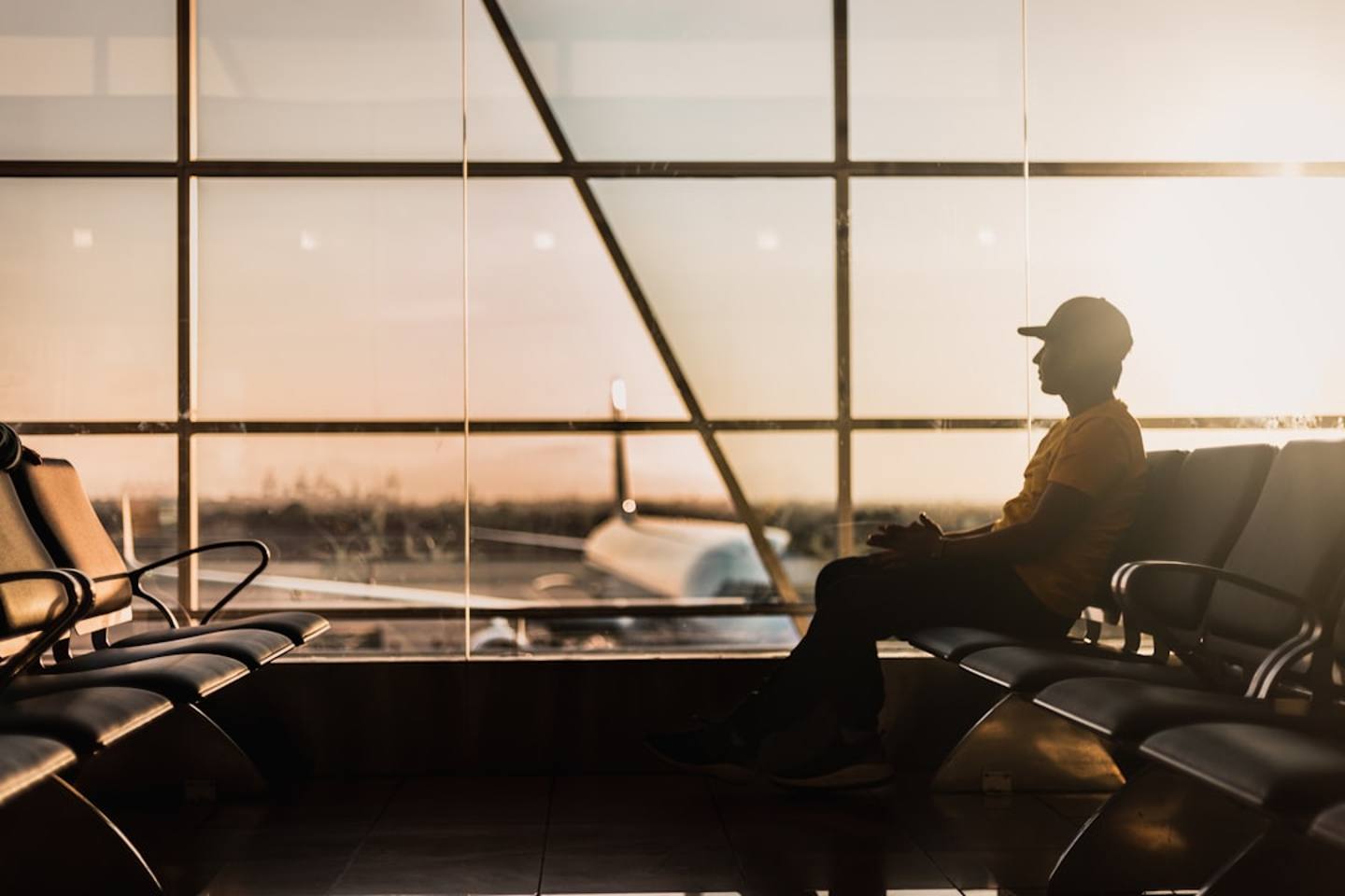 Business traveler checking a food allergy business travel checklist before boarding a flight at a busy airport terminal
