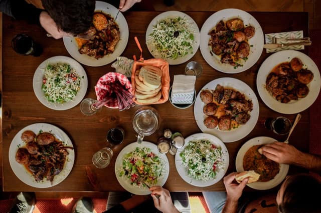 Diverse diners at a multicultural table illustrating cultural dining etiquette to refuse food politely across different traditions